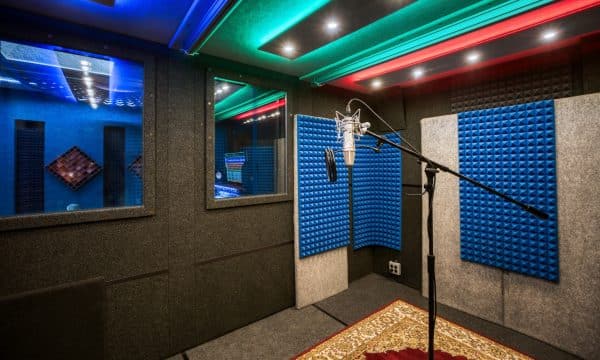Vocal booth with glass windows, acoustic panels, and the incredible Neumann U87 microphone.