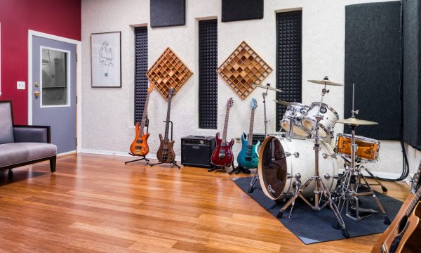 Wide right-side view of live room with full drum kit and acoustic wall treatment.
