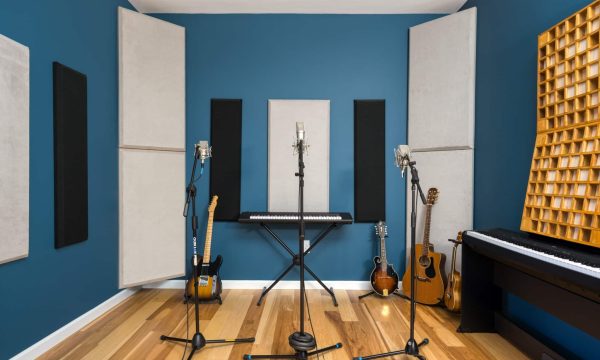 Wide angle of Room C with three microphones set up and wood paneling.